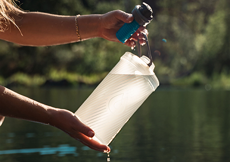 wellness water company - a woman is holding a water jug and a camera