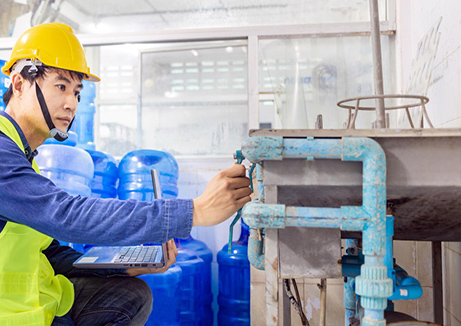 wellness water company - a man in a hard hat working on a machine