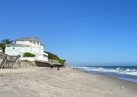 wellness water company - a sandy beach with a house on top of it